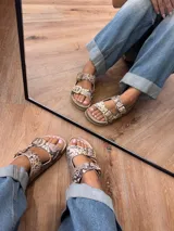 Sandalias con estampado de reptil, confeccionadas 100% en cuero, con plantilla de cuero y hebillas doradas.