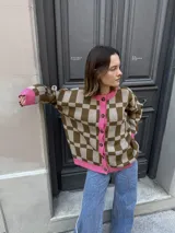 Cárdigan marrón con estampado a cuadros beige, ribete rosa y botones al frente.