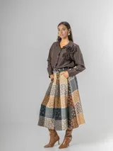 Camisa de corte clásico, color marrón oscuro con brillo sutil dorado, confeccionada en tela nacarada. Presenta apliques de flores tridimensionales fruncidas en el área del pecho.