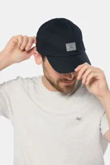 Gorra de béisbol azul marino confeccionada en lona de algodón, con visera curva y parche rectangular con logo en el frente.