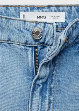 Pantalón de jean celeste de corte wide leg, tiro alto, cinco bolsillos, cierre con cremallera y botón, trabillas para cinturón y bajo deshilachado.