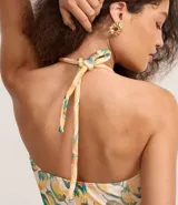 Body femenino con estampado de bananas en tonos amarillo, naranja y verde. Diseño de frente única con lazo anudado en el centro del busto que genera un corte tipo ojal.