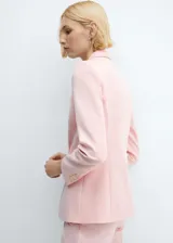 Blazer entallado color rosa pálido, con cuello de solapa de muesca, manga larga, hombros estructurados, dos bolsillos de ribete en la parte delantera, cierre de botón en la parte delantera, detalle de pinzas, abertura posterior y forro interior.