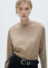 Remera color beige de manga larga con cuello redondo.
