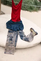 Pollera corta estilo balloon de denim azul oscuro, con cintura alta y detalle de frunce o volado en la parte inferior. Tiene un parche de marca metálico en la cintura.