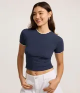 Remera ajustada de manga corta, color azul marino, con cuello redondo ribeteado en blanco.