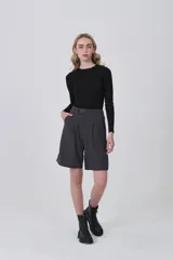 Bermuda de poliéster color gris oscuro, con pinzas frontales y corte holgado. Presenta un calce a media pierna.