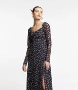 Vestido midi de tul negro con estampado floral liberty en tonos lila, escote cuadrado con lazo, mangas largas y abertura lateral.