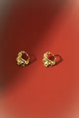 Aros de estilo orgánico, con forma irregular y textura martillada, en tono dorado.