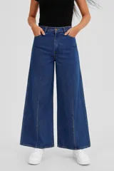 Pantalón de jean azul oscuro, de corte ancho y tiro medio, con bolsillos delanteros y traseros.