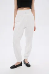 Pantalón babucha blanco con cintura elastizada y cordón ajustable.