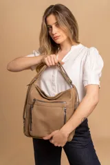 Cartera mochila color marrón de símil cuero suave con múltiples bolsillos con cierre, división al medio y correa ajustable de doble manija para llevar al hombro y como mochila.