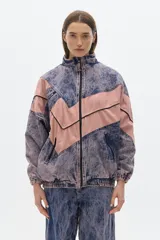 Campera estilo olímpica de jean con lavado gastado en azul y rosa. Corte oversized, con elástico en la cintura y bolsillos al frente con cierre.