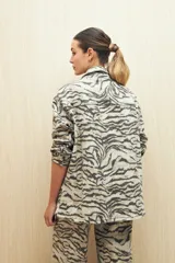 Sobrecamisa de calce amplio con estampado animal print, cuello camisero, cierre con botones, bolsillos frontales y ruedo redondeado.