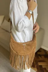 Bandolera de gamuza color marrón chocolate, con flecos largos y logo de la marca Pecari.