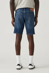 Bermuda de jean de calce slim, color azul medio, con bolsillos delanteros y traseros.