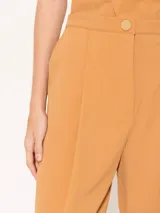 Pantalón baggy color ocre, confeccionado en poplin 4way con largo hasta los tobillos. Presenta diseño con tabla en cintura y ruedo, bolsillos laterales escondidos, elástico en la espalda y cierre con broche, cierre y botón interno.