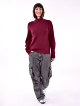 Sweater de punto color borgoña, con cuello alto y mangas largas.