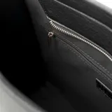 Bolso tote grande color negro, confeccionado en símil cuero graneado. Tiene doble asa corta, correa larga regulable y acceso con cierre. Cuenta con un compartimento principal con dos bolsillos abiertos y uno con cierre.