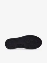Zapatillas deportivas de dos tonos en piel, con diseño blanco y negro, puntera perforada y cierre de cordones.
