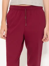 Pantalón babucha color café, confeccionado en algodón liviano, con cintura elastizada, cordón ajustable, bolsillos laterales y botamangas levemente entalladas.