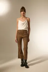 Pantalón de jean estampado camuflado en tonos marrón y beige, de corte flare y tiro alto.