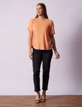 Remera color durazno con textura y espalda con aplique de botones.