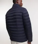 Campera puffer ultraligera color beige, con cuello alto, cierre por cremallera y bolsillos con cremallera. Incluye bolso de almacenamiento.
