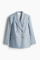 Blazer celeste de doble botonadura con solapas de pico, hombreras finas, bolsillos delanteros ribeteados con solapa y puños abotonados con abertura decorativa. Forrado.