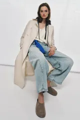 Zapato plano tipo mule destalonado confeccionado en serraje color marrón, con detalle de pespunte en el cuerpo y punta redonda.