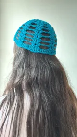 Gorro tejido al crochet color turquesa, con diseño calado.