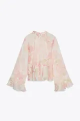 Camisa de cuello subido y manga larga con estampado floral en tonos rosa y verde. Detalle de volantes en cuello, mangas y ruedo. Cierre en espalda con abertura y botones.