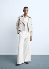 Pantalón de jeans estilo wideleg, color blanco crudo, tiro medio, con cierre de botón y cremallera, y detalle de pinzas delanteras.