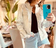 Campera de cuero ovino italiano plateada con cuello clásico, cierre frontal con botones a presión, dos bolsillos con solapa en el pecho y dos bolsillos laterales con cierre. Corte entallado.