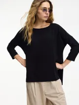 Sweater negro de punto con cuello redondo y mangas 3/4. Tiene corte amplio y tajos laterales.