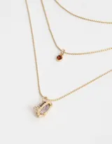 Collar dorado multicadena con dije de corazón rosa y dije de cristal rojo.