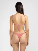 Conjunto de bikini color rosado con textura acanalada. El corpiño es de corte triangular con tirantes finos y la bombacha es tipo colaless.