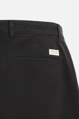 Pantalón chino azul marino, corte skinny fit, confeccionado en tejido de algodón con elasticidad. Cuenta con bolsillos frontales y traseros de vivo. Cierre frontal con cremallera y botón.