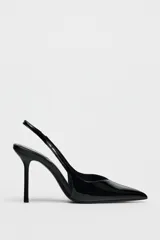 Zapato destalonado negro acharolado con tacón fino y punta. Tiene una tira trasera con elástico.