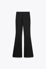 Pantalón negro de tiro alto confeccionado en tejido de punto elástico y flexible con trama compacta, mullida y opaca. Bajo acampanado.