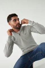 Sweater gris de punto con medio cierre, cuello alto y logo bordado en el pecho.