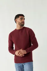 Sweater mostaza de punto con cuello redondo, mangas largas y logo bordado en el pecho. Corte slim fit.