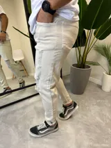 Pantalón de jean skinny color arena con roturas en las rodillas.