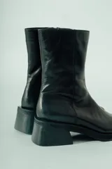 Bota corta de cuero color bordó con acabado natural, caña ajustada y punta suavemente afinada. Posee un taco ancho y estable de aproximadamente 5 cm.