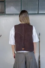 Chaleco marrón de cuero con tachas doradas, forrado y con bolsillos.