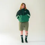 Campera deportiva unisex de nylon liviano, color negro, verde y gris, con paneles diagonales en contraste, calce relajado y estructura clásica. Incluye micrográfico de "encontrame en el under" aplicado al frente y un gráfico en la espalda.