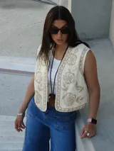 Chaleco color natural con bordados de flores en hilo color beige.