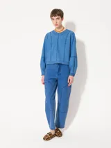 Top de manga larga color azul, confeccionado en denim paper touch. Presenta cuello redondo y recortes en el frente que estilizan la silueta. Tiene cartera en la espalda con broches para facilitar el acceso.