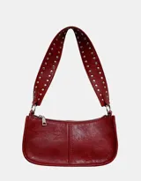 Cartera baguette color borgoña con correa corta con tachas plateadas.