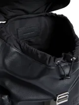 Mochila negra de estilo cargo con textura granulada, solapa superior con cierre de correa ajustable y hebilla metálica. Presenta un asa de mano superior y una correa textil gris con el logo "Calvin Klein" en relieve. Incluye un logo CK grabado en la parte inferior frontal.